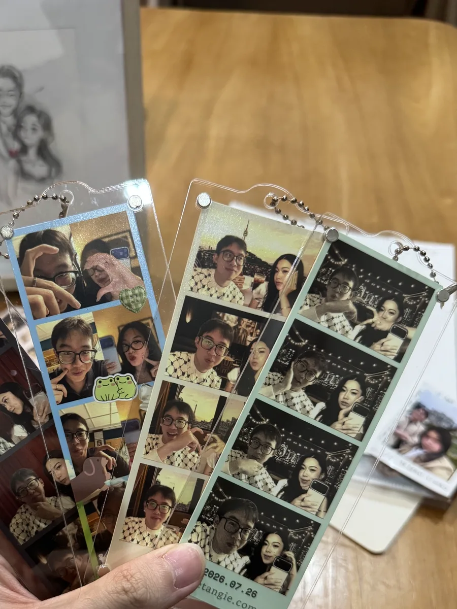 Acrylic photostrip keychains held in a hand.